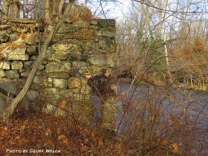 Ed Marse peeks around the remains of Brown's Bridge, which at one time spanned the Ramapo River in Sloatsburg, leading to Cappamore Farms.