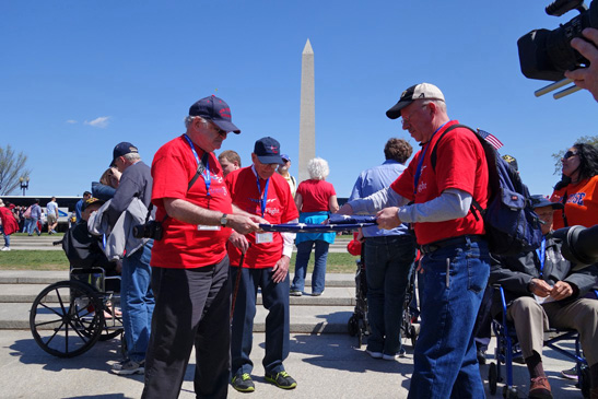 Sloatsburg veterans hold a flag folding ceremony in Washington, D.C., with the Washington Monument rising in the background. / Photo by Mike & Daphne Downes