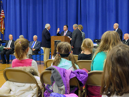 Sloatsburg's Tom Bollatto  (left at podium) swears in Assemblyman Carl Brabenec at recent Sloatsburg Elementary School ceremony. Photo courtesy of Ramapo Central Schools.