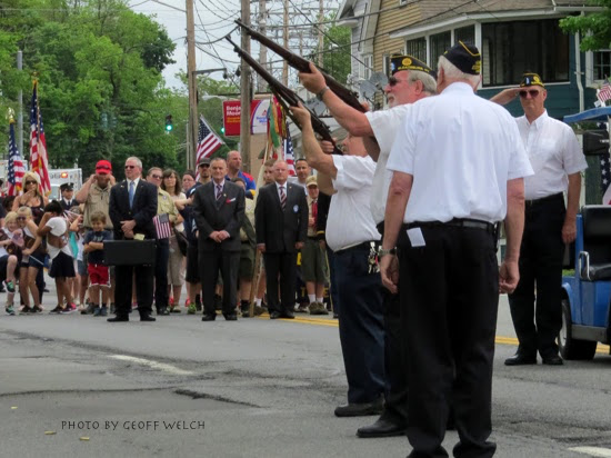 Members of Sloatsburg American Legion Post 1643 salute at the veterans memorial while Peter Head plays Taps.